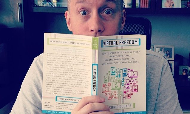Chris Ducker holding his bestselling book Virtual Freedom, 2014